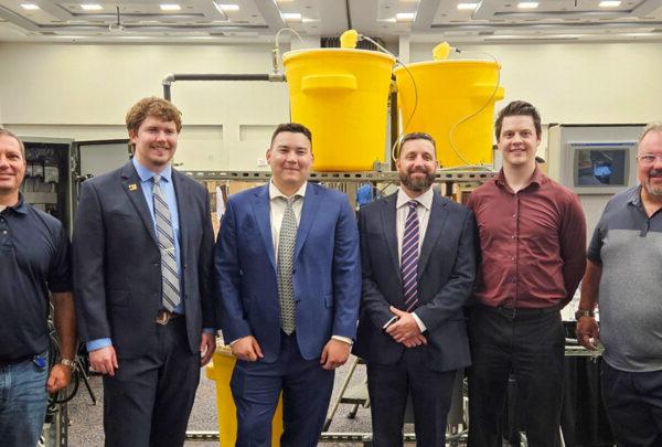 UNF Process Skid team members pose in front of their senior design project. From left are Greg Kline of Vega Americas; Daniel Fowler, Electrical; Adrian Hoover, Mechanical, Bryce Lovelace, Mechanical; Lake Miller, Electrical; and 澳门足彩app’s Christian Beckman.