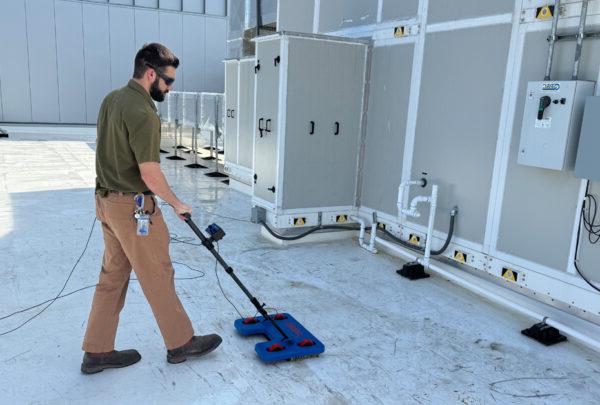 Quality Coordinator Grant Foreman operates the IntegriScan Electronic Leak Detection system on the roof of Miller Electric Center, the Jacksonville Jaguars practice facility and sports performance center.